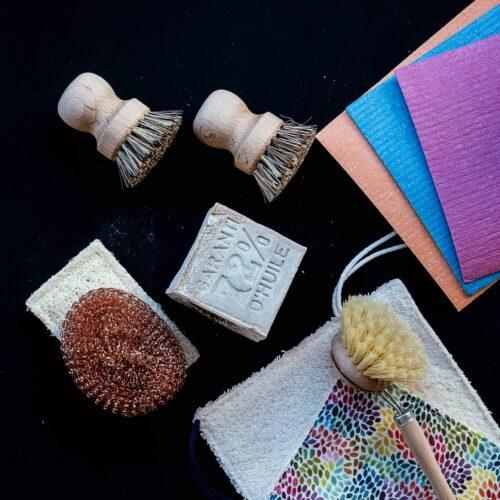 Esponjas de metal, cepillos, bayetas, papelería, etc. sobre fondo negro