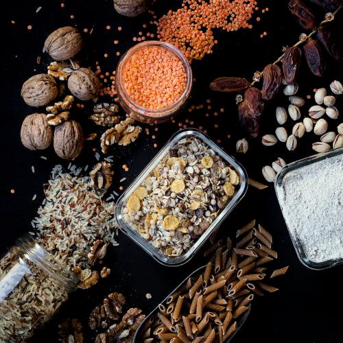 Imagen de pastas, nueces, harinas, semillas sobre fondo negro